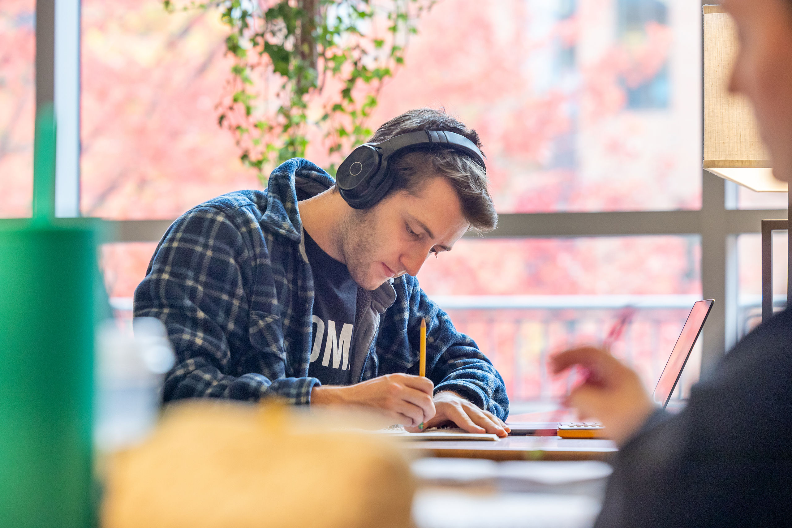 student working on a computer in front of large windows