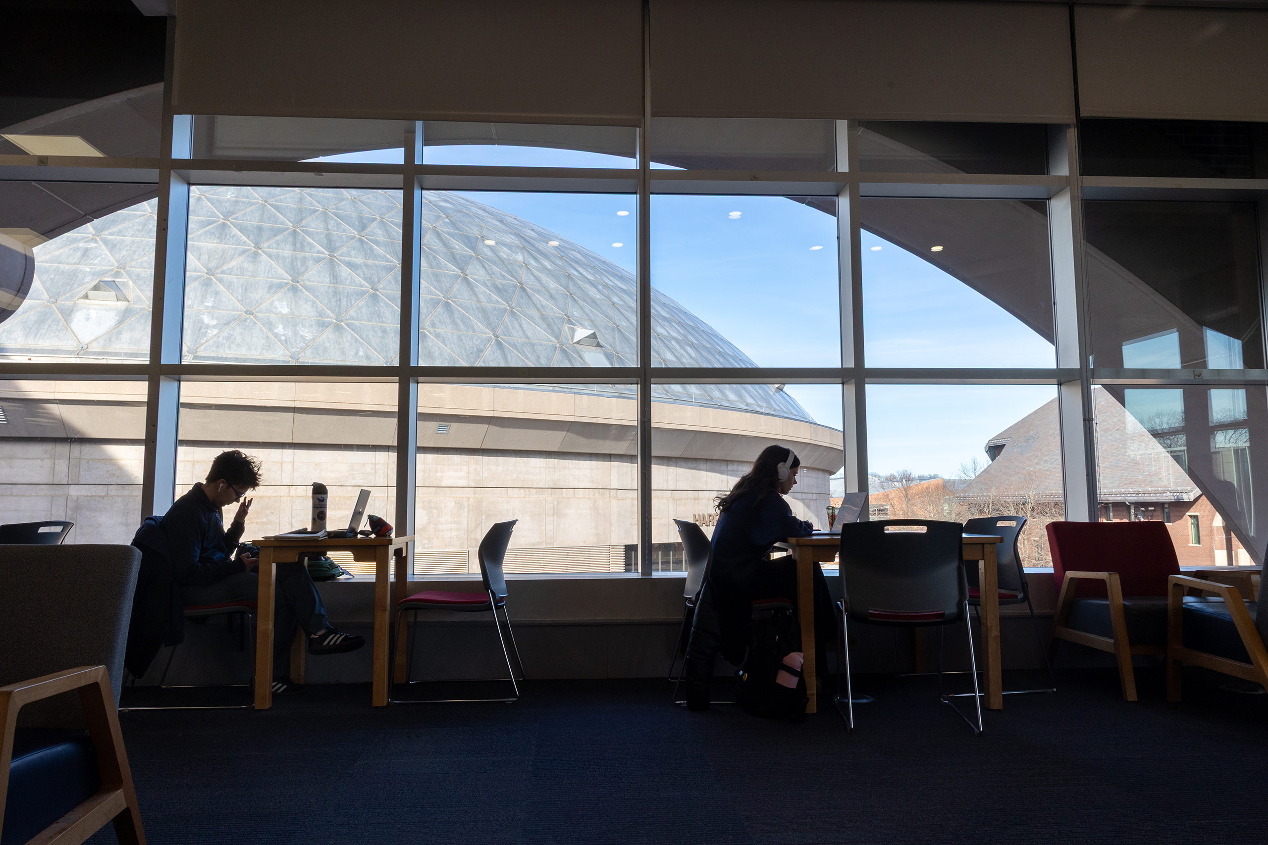 students working in front of a large window with Gampel in the distance