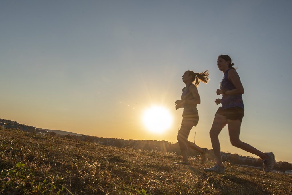 students running on horsebarn hill at sunset